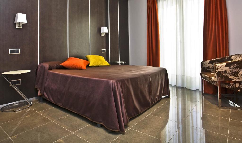 1 dormitorio con 1 cama con 2 almohadas de colores. en Hostal Alcalá Del Jucar, en Alcalá del Júcar