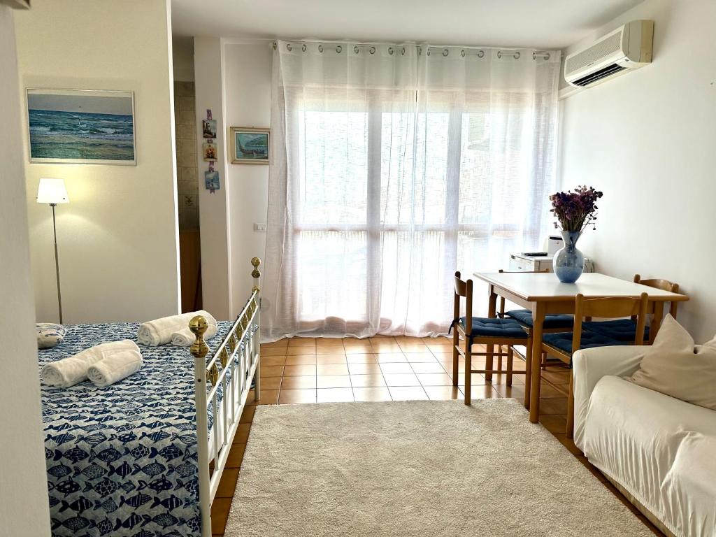 1 dormitorio con cama, mesa y ventana en Marina Bay View Apartment, en Bevazzana