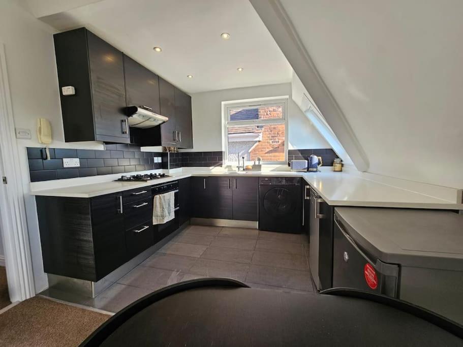 a kitchen with black cabinets and a white counter top at 2 bedroom Flat in Camden in London