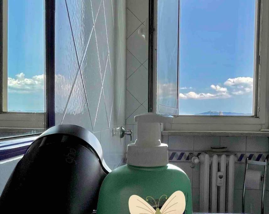 uma garrafa verde com uma borboleta ao lado de uma janela em Panoramic 7 em Turim