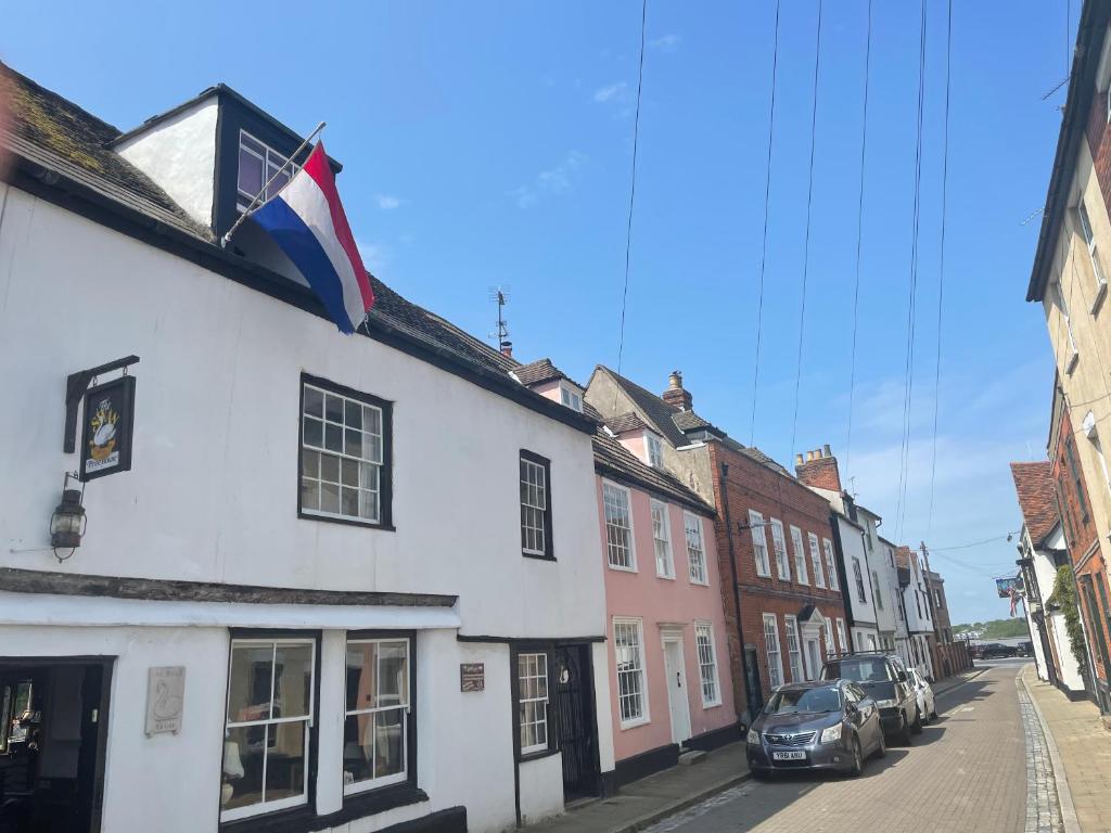 a white building with a flag on the side of it at The Swan Inn in Harwich