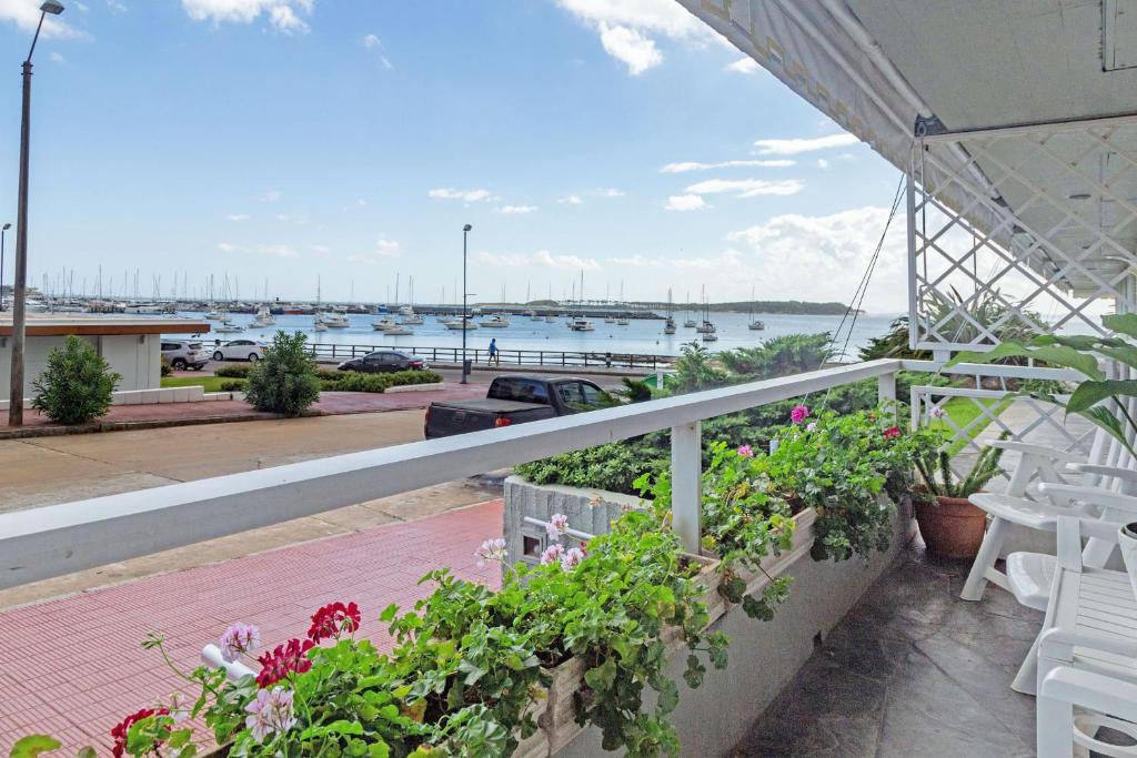 a balcony with flowers and a view of the water at Oceana Suites Remanso in Punta del Este