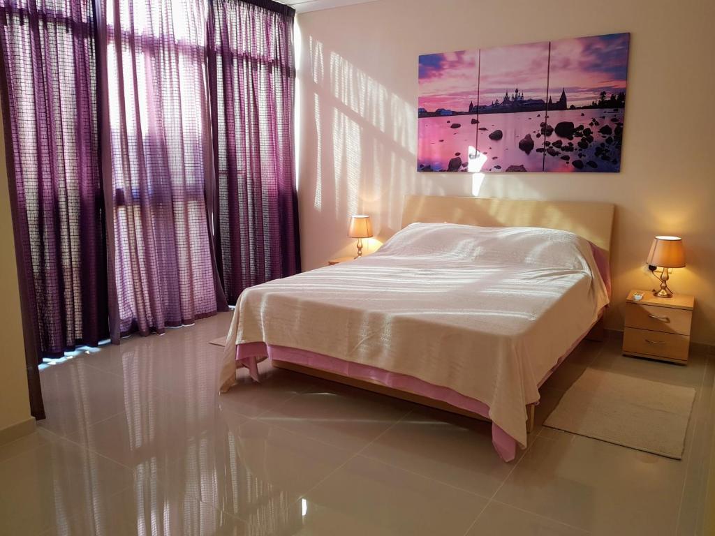 una camera da letto con un letto e un dipinto sul muro di Charming apartment-wifi-sleeps 5 a Marsaskala
