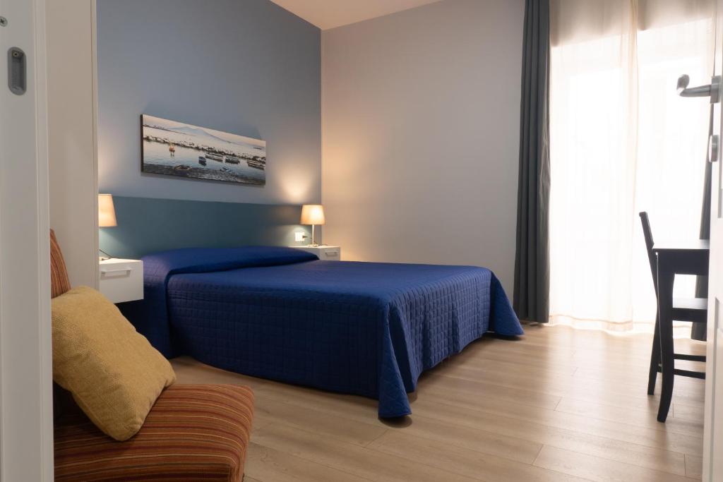 a blue bedroom with a bed and a chair at Casa Amato_2_Regina Giovanna in Naples