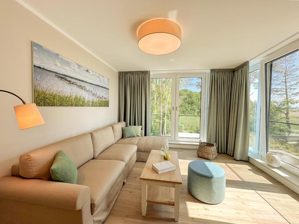 a living room with a couch and some windows at Appartements "Zum Leuchtturm" Hafen Rankwitz Insel Usedom in Rankwitz