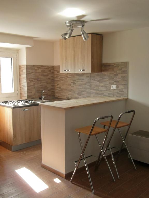 a kitchen with two chairs and a counter and a sink at La piccionaia in Aosta