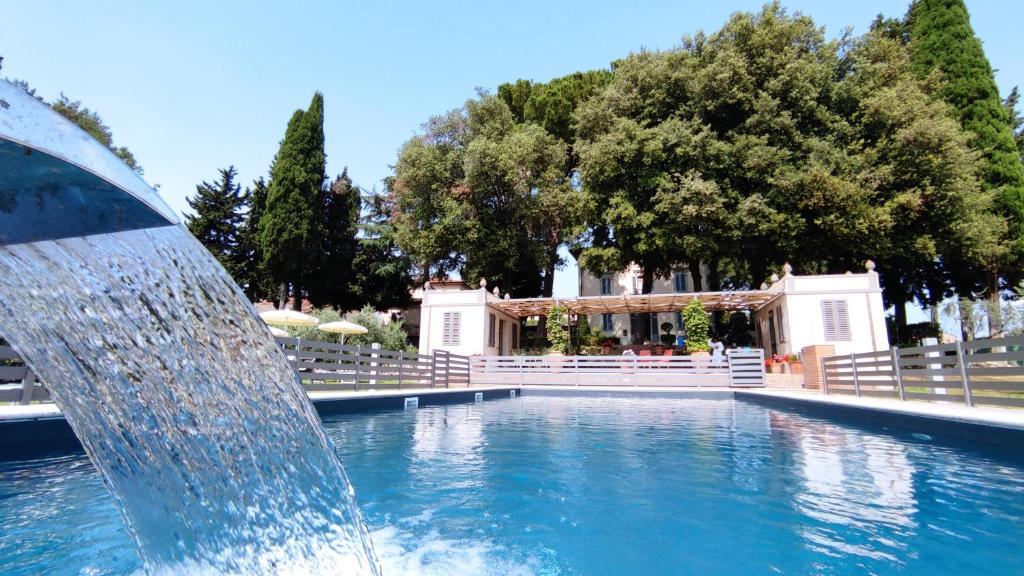 a water fountain in the middle of a pool at Villasanpaolo Resort & Spa in San Gimignano