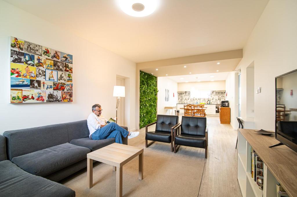 un hombre sentado en un sofá en una sala de estar en Livramento Residence, en Livramento