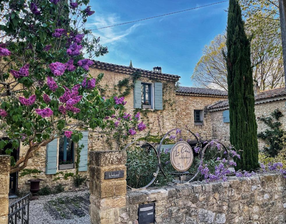 a stone house with a sign in front of it at La Belugue in Beaumont-de-Pertuis