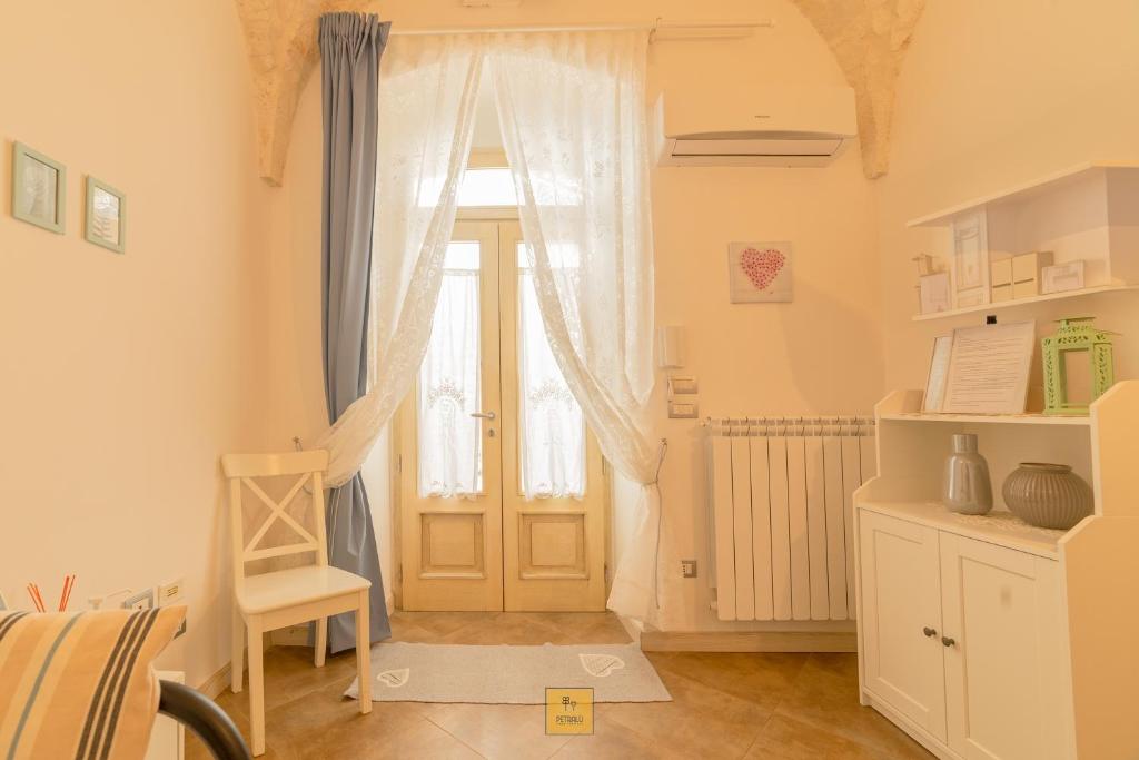 a room with a door and a chair and a window at Petralù - Casa Vacanza zona centro in Locorotondo