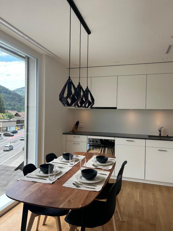 cocina con mesa de madera y sillas negras en The R Apartment Engelberg, KLIMA, NEU, Balkon, Parking, en Balsthal