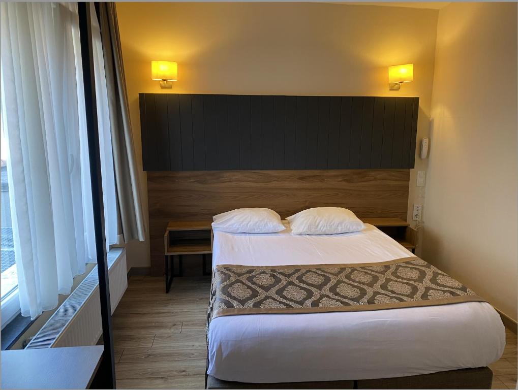 Habitación de hotel con 1 cama con 2 almohadas en Hotel Prestige, en Bruselas