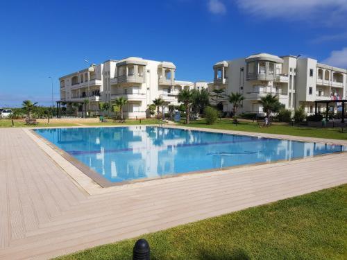 a large swimming pool in front of some apartments at Bahia golf beach in Bouznika