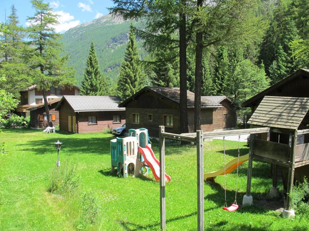 a playground in a yard with a house at Residenz Edelweiss SAAS320 in Saas-Balen