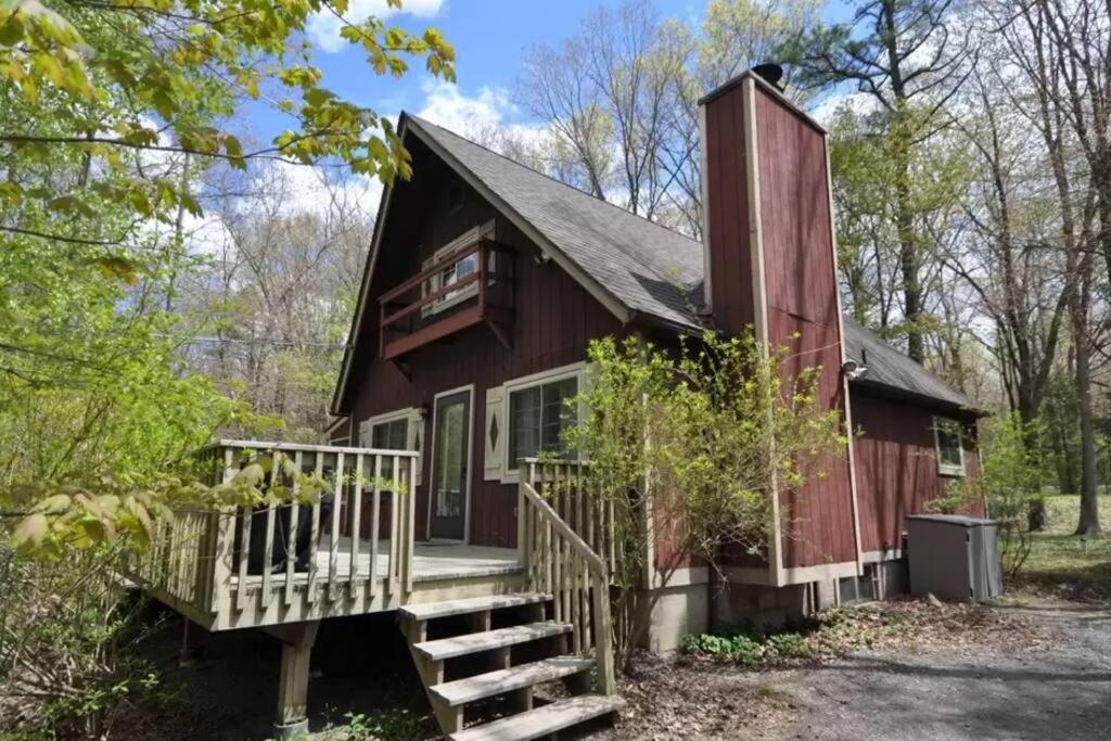 a red house with a porch and stairs leading up to it at Chalet Retreat w/ Hot Tub, Short Walk to Lake & Pool in Jim Thorpe