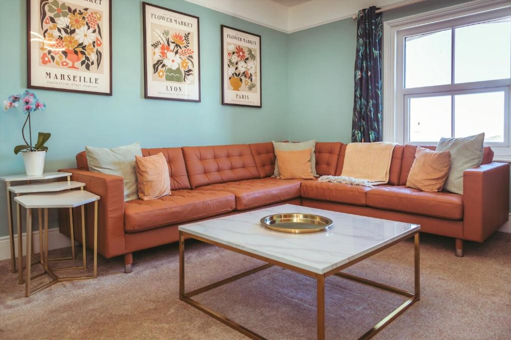 een woonkamer met een bank en een tafel bij Central Breaks - split level, spacious getaway in Eastbourne