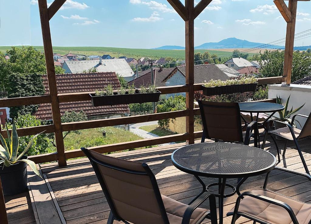 a deck with tables and chairs and a view of the city at Penzion Levandule a Palava in Starovičky