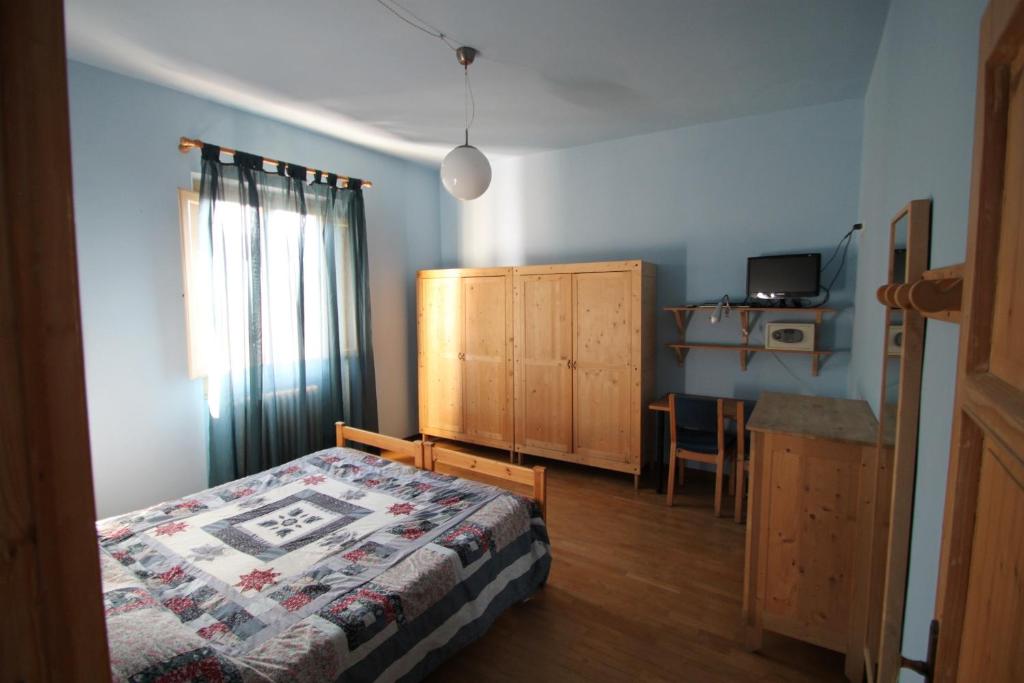 1 dormitorio con cama, mesa y TV en Alla Porta di Baccio, en Lastra a Signa