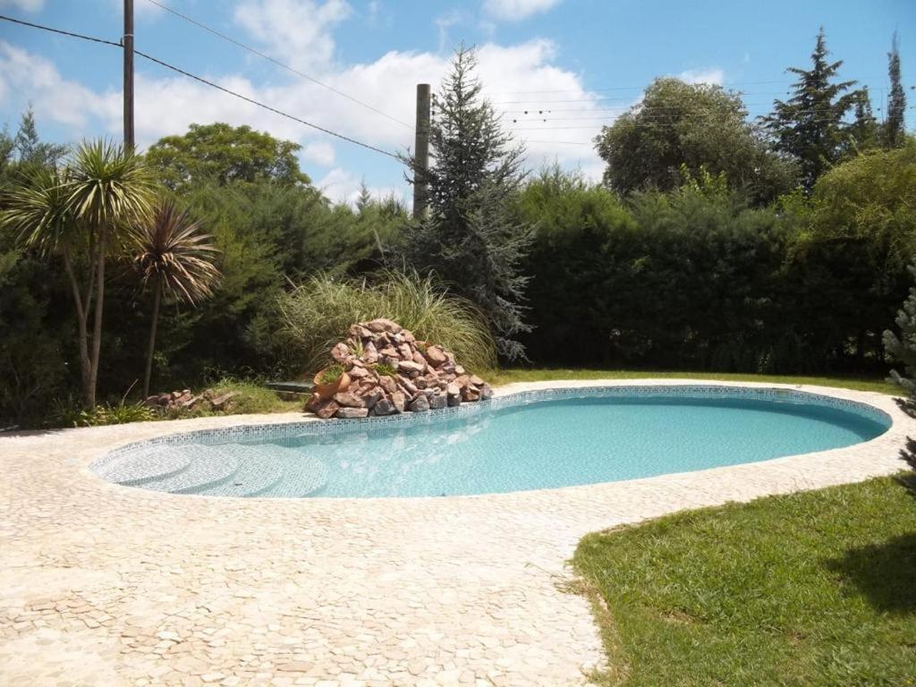 a small swimming pool with a fire pit in the grass at DINASTIE COUNTRY APART in Villa Rumipal