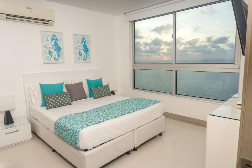 1 dormitorio con cama y ventana grande en Apartamento 3404 Palmetto Beach Frente a la playa, en Cartagena de Indias