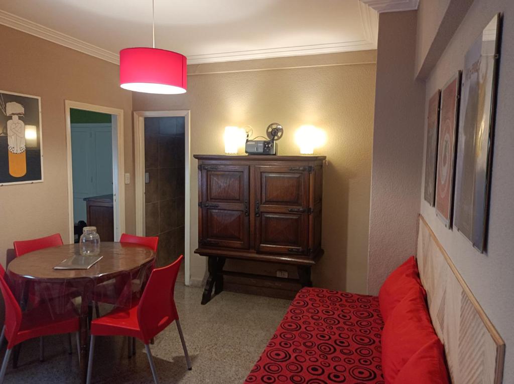 un comedor con una mesa y sillas rojas y una habitación en Departamento Legarra Mar en Miramar