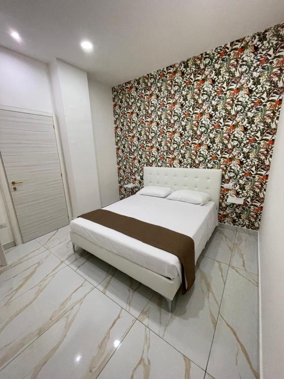 a bedroom with a bed and a floral wall at Life Hotel in Casalnuovo di Napoli