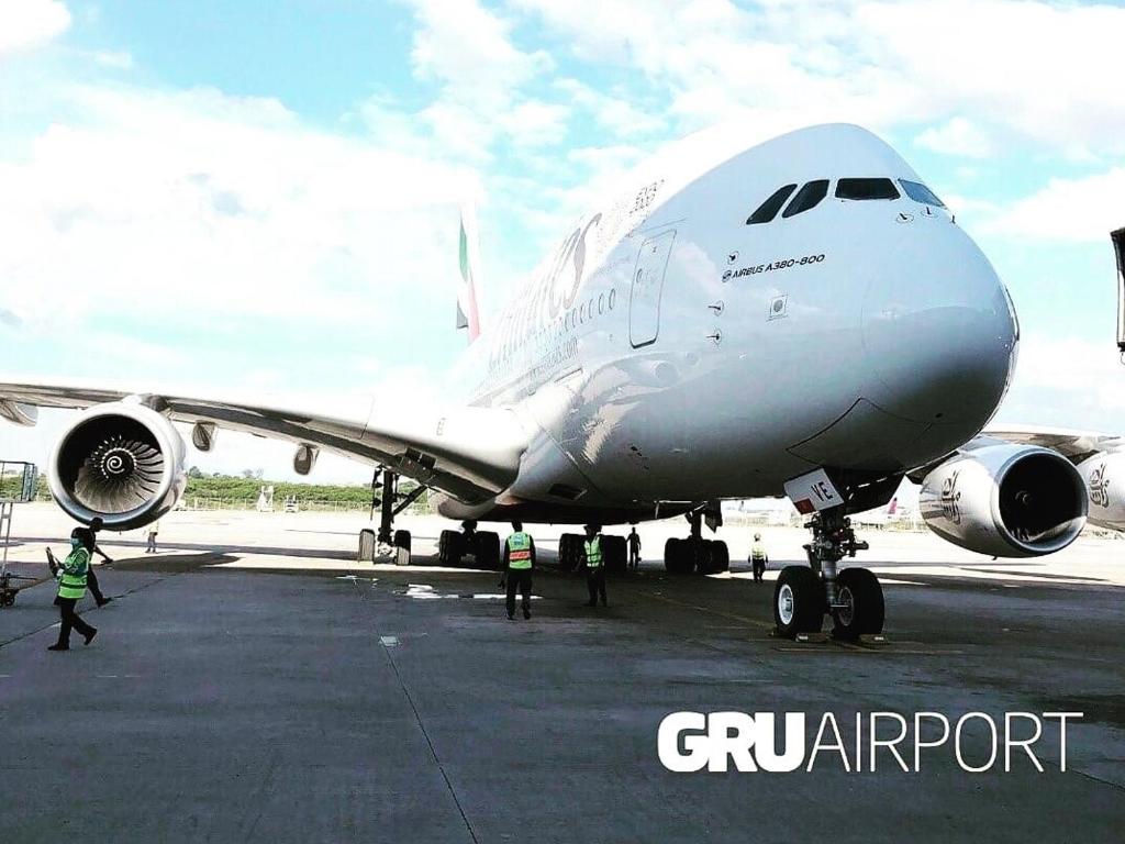 a group of people standing next to an airplane on a runway at kitnet casa completa in Guarulhos