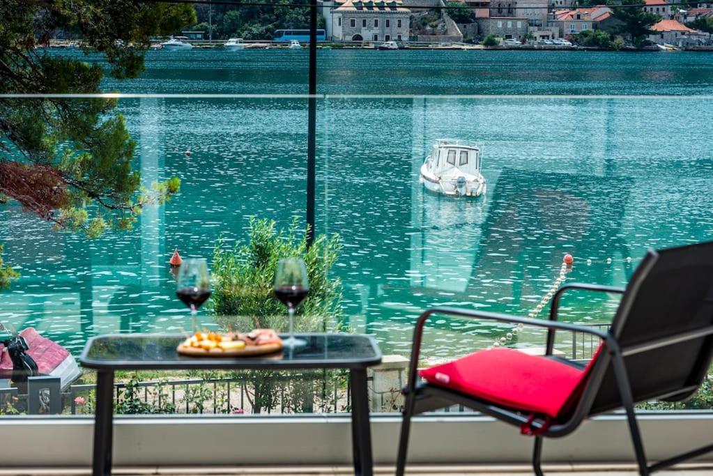 a table with a plate of food and two glasses of wine at Mariva Dubrovnik in Mokošica