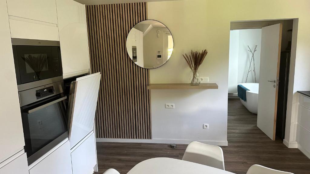 uma sala de estar com um espelho e uma banheira em Au petit alveo em Sprimont