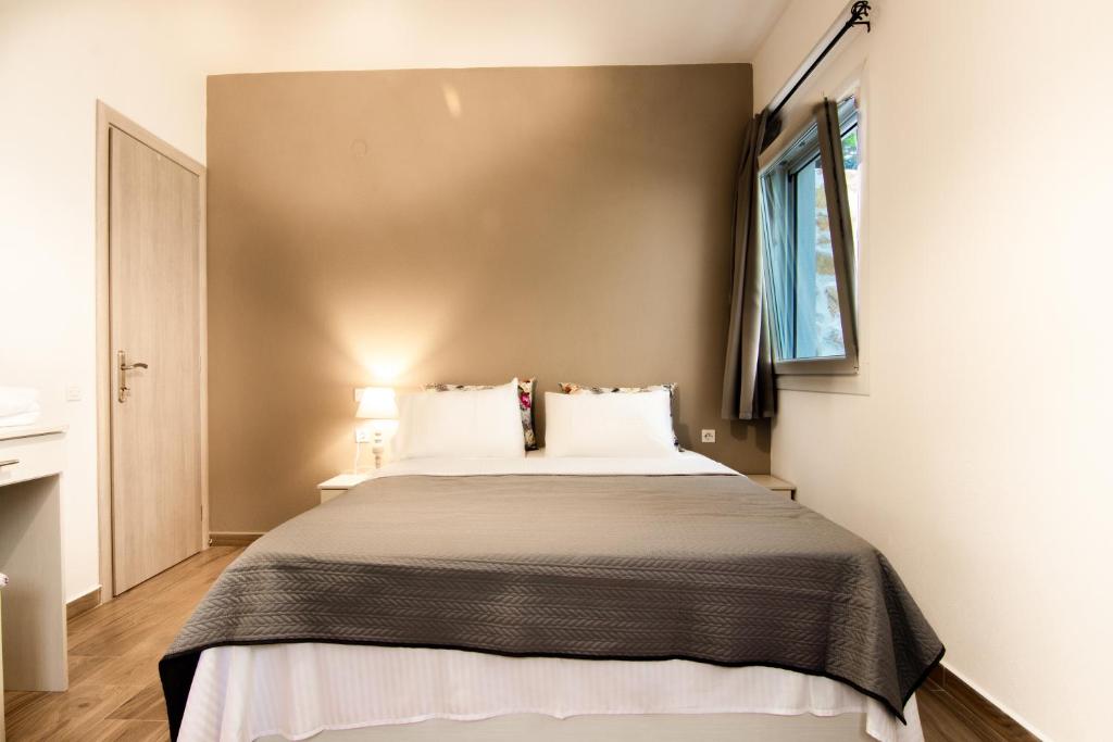 1 dormitorio con 1 cama grande con almohadas blancas en Evergreen Thassos en Skála Potamiás