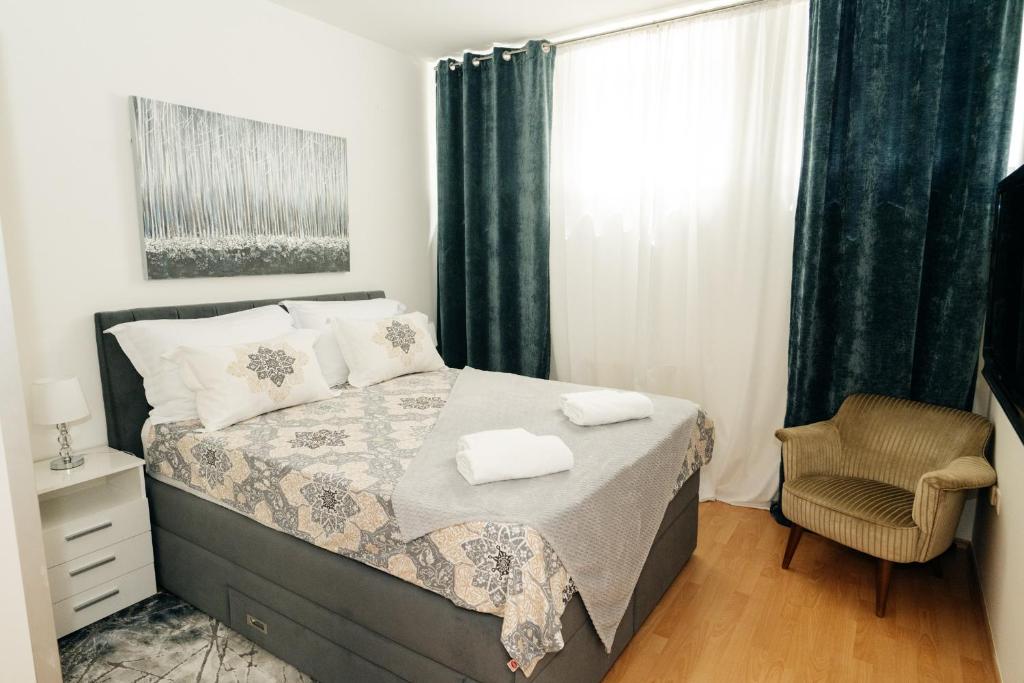 una camera con un letto e una sedia e una finestra di KM Apartments a Zagabria