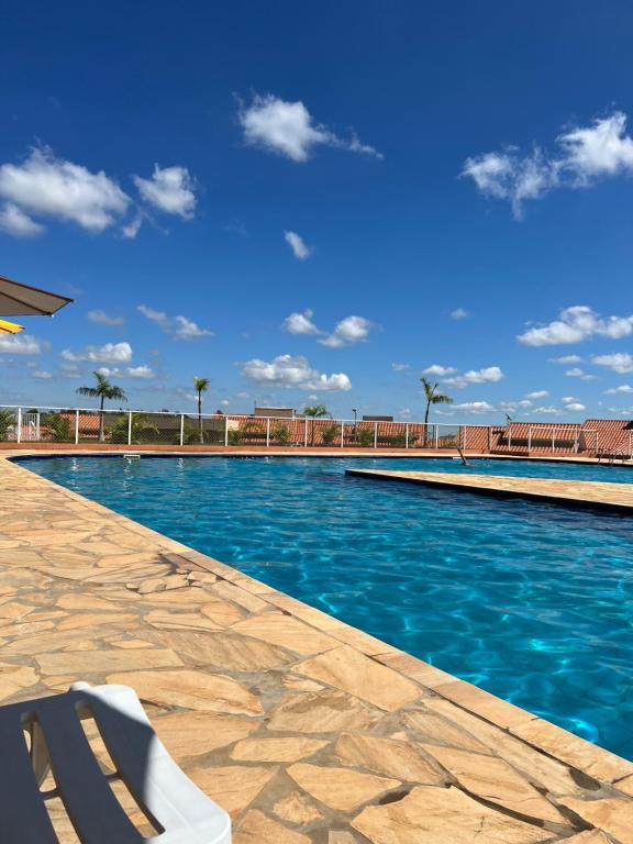 uma piscina com um banco em frente em Chalé em Resort em Mairinque