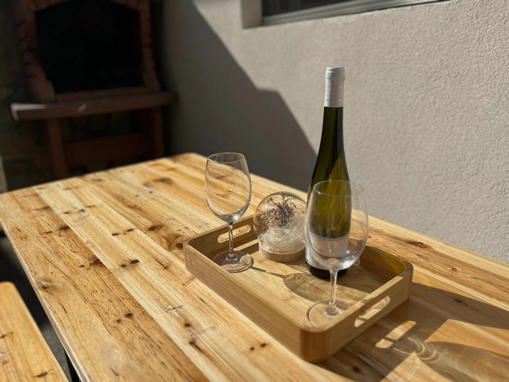 a bottle of wine and two glasses on a wooden table at Secret Place Apartment in Stari Grad