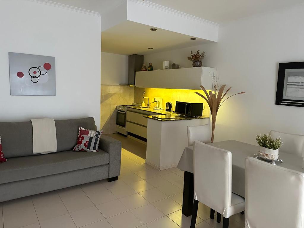 uma sala de estar com um sofá, uma mesa e uma cozinha em Oasis del Sur em Puerto Madryn