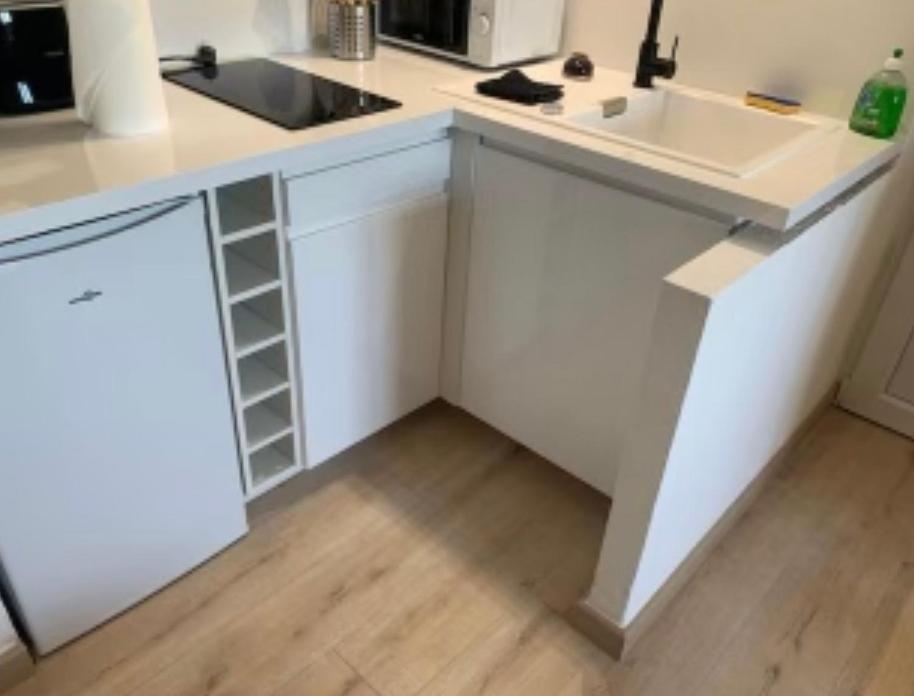 a white kitchen with a sink and a counter at Exceptionnel studio vue mer refait à neuf in Rayol-Canadel-sur-Mer