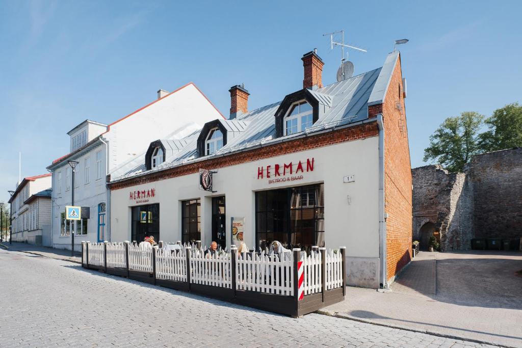 a white building with a fence in front of it at Hermannuse Maja in Haapsalu