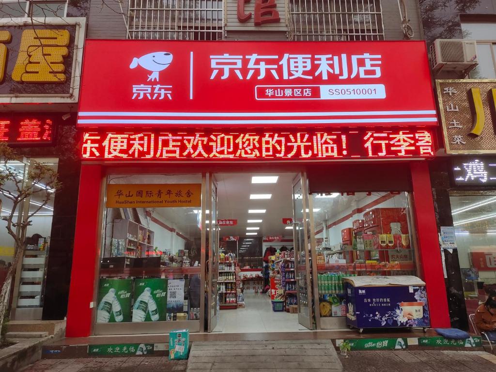 a store with a red sign on the front of it at Huashan International Youth Hostel in Huayin