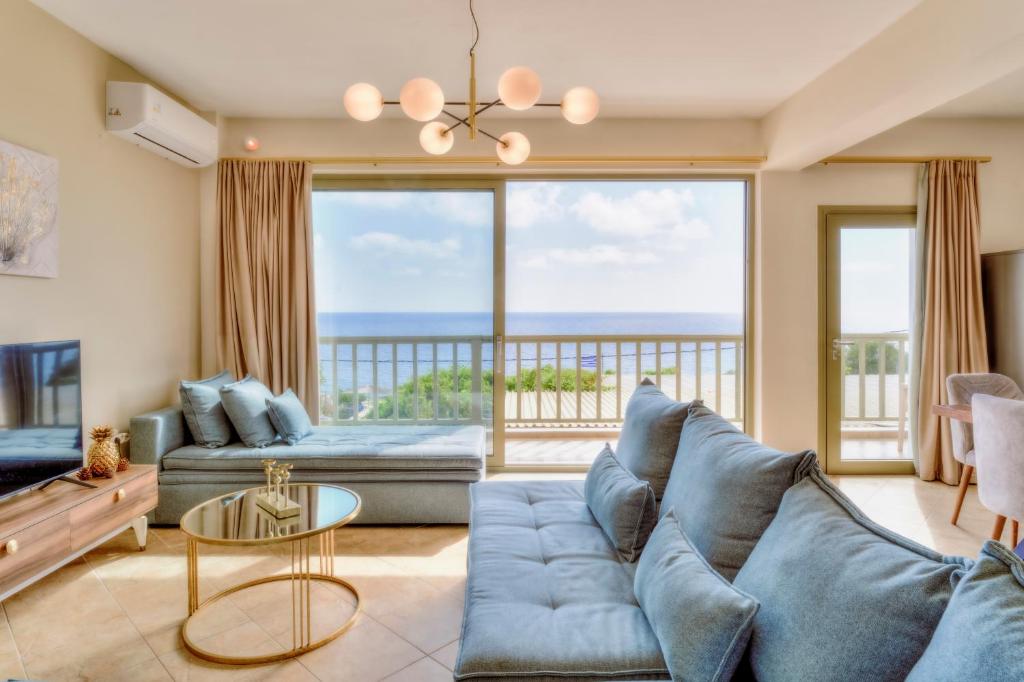 ein Wohnzimmer mit einem blauen Sofa und Meerblick in der Unterkunft Roxa seaview apartment in Agios Leon