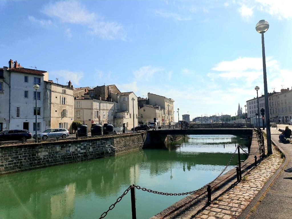 un pont sur une rivière dans une ville dans l'établissement Maison sur le quai, à La Rochelle