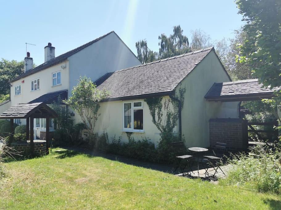 una casa blanca con una mesa de picnic delante de ella en Canalside Cottage, en Barton under Needwood