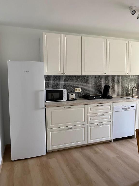 a kitchen with white cabinets and a white refrigerator at L&#39;Harmonie de Wavre in Wavre