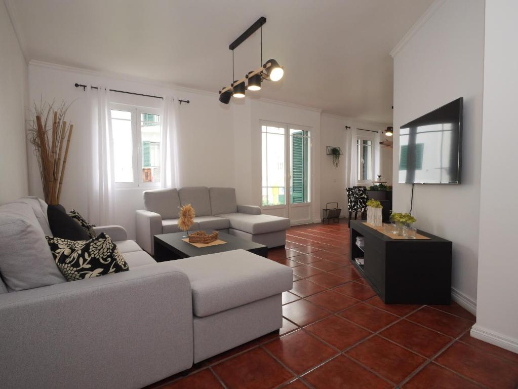ein Wohnzimmer mit einem Sofa und einem Tisch in der Unterkunft Forte do Ilhéu de Vila Franca in Vila Franca do Campo