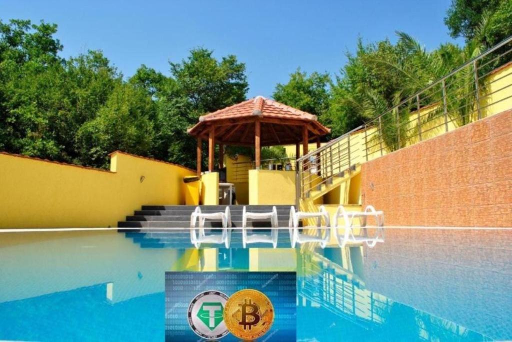 een zwembad met een tuinhuisje aan de zijkant van een huis bij Krypto Villa G in Herceg-Novi