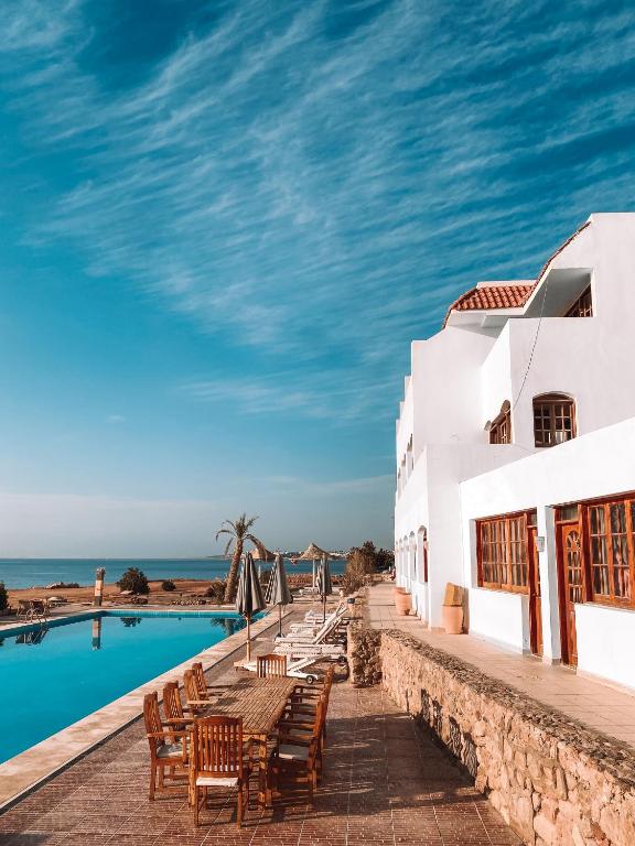 un resort con piscina, tavoli e sedie di Serenity Lodge a Sharm El Sheikh