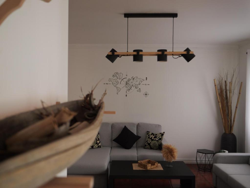 a living room with a couch and a chandelier at Forte do Ilhéu de Vila Franca in Vila Franca do Campo