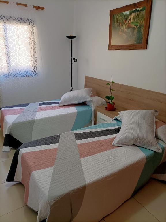 zwei Betten, die in einem Zimmer nebeneinander stehen in der Unterkunft Vivienda vistas bonitas in Calera