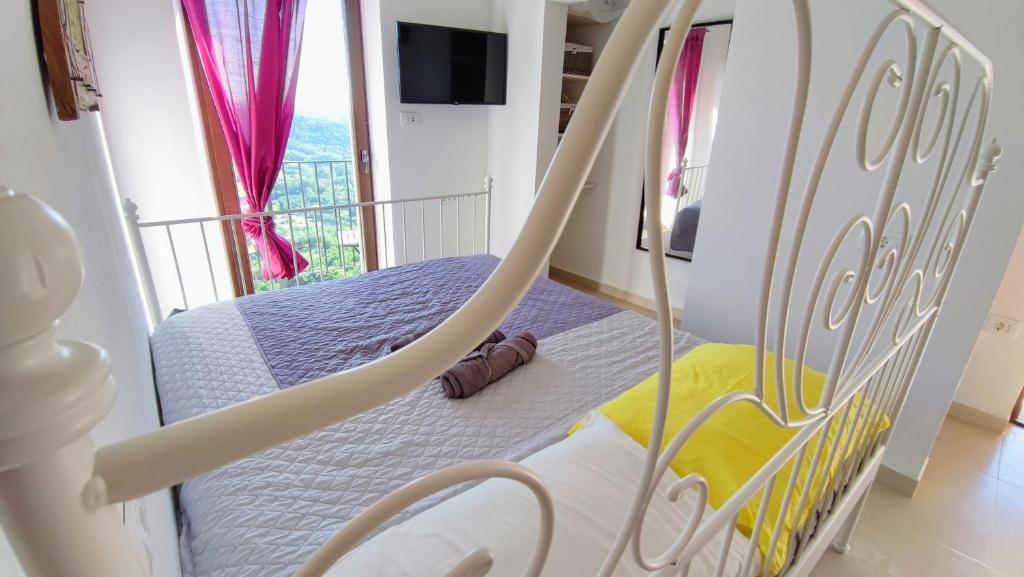 1 cama columpio en un dormitorio con balcón en STUDIO CASA FERMEGLIA for two people en Roč