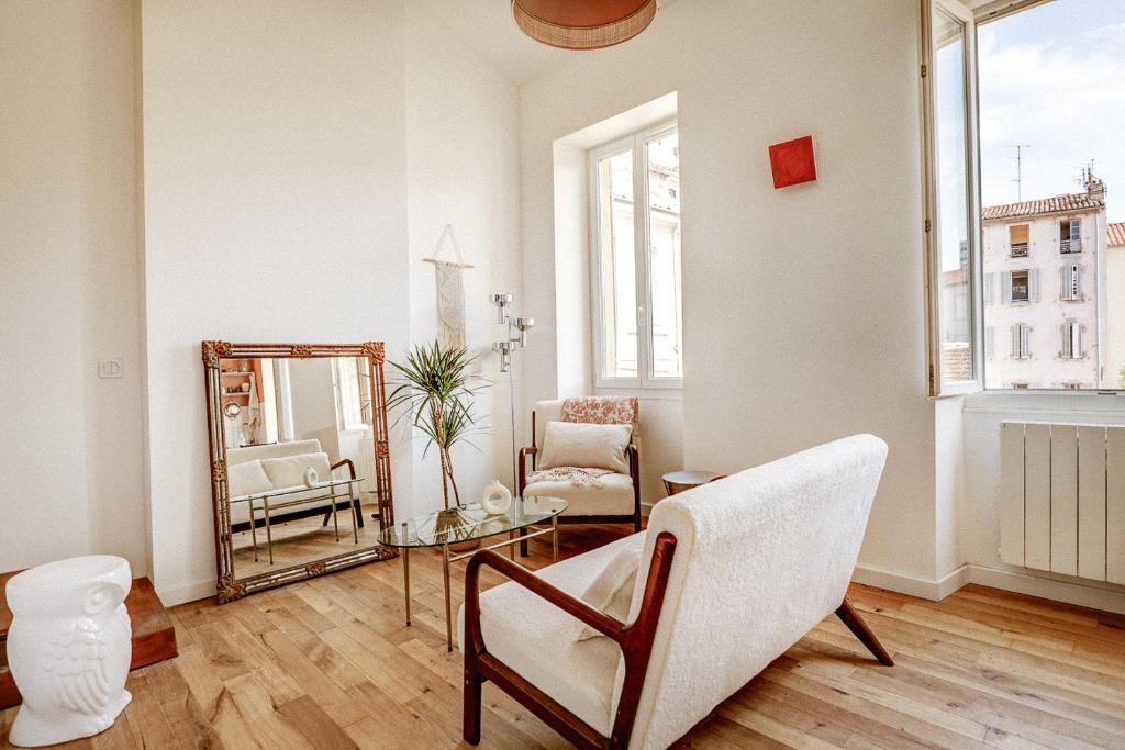 un salon avec un miroir et une chaise dans l'établissement Appartement T3 en duplex, Marseille 7, à Marseille
