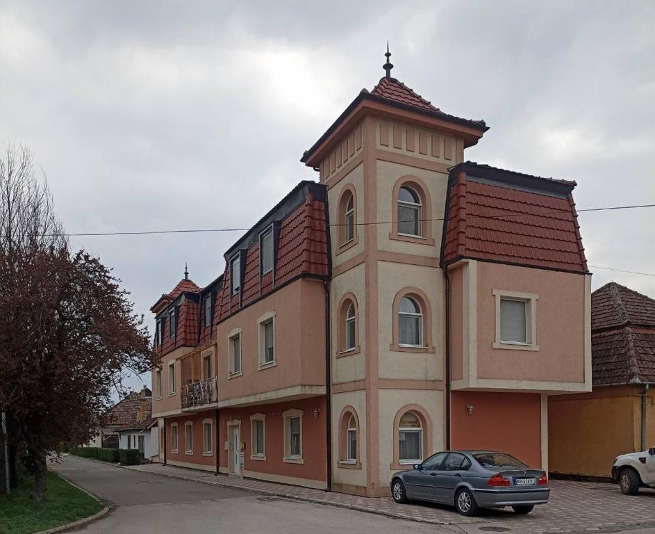 a large building with a clock tower on a street at Studio apartman MIR in Kanjiža