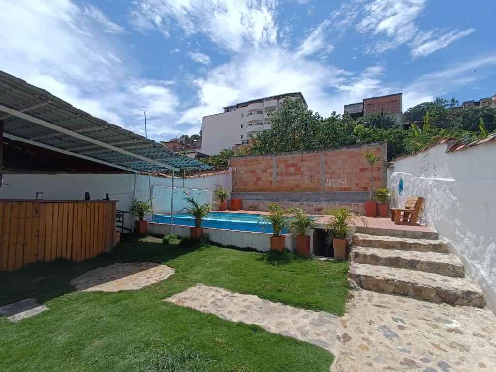 a small backyard with a swimming pool and grass at The Best Adventure Hostel in San Gil